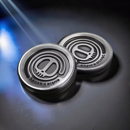 The Curious Mind Demon Coin Push Card Clicker fidget toy, silver metal with skull emblem and textured edge.