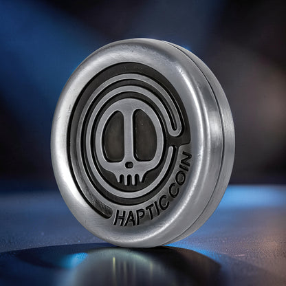 The Curious Mind Demon Coin Push Card Clicker, a metal fidget toy with a skull design and "HAPTIC COIN" text, offering tactile feedback.
