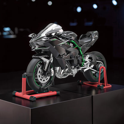The Curious Mind 1/6 diecast motorcycle model in black with green accents, displayed on a red stand.