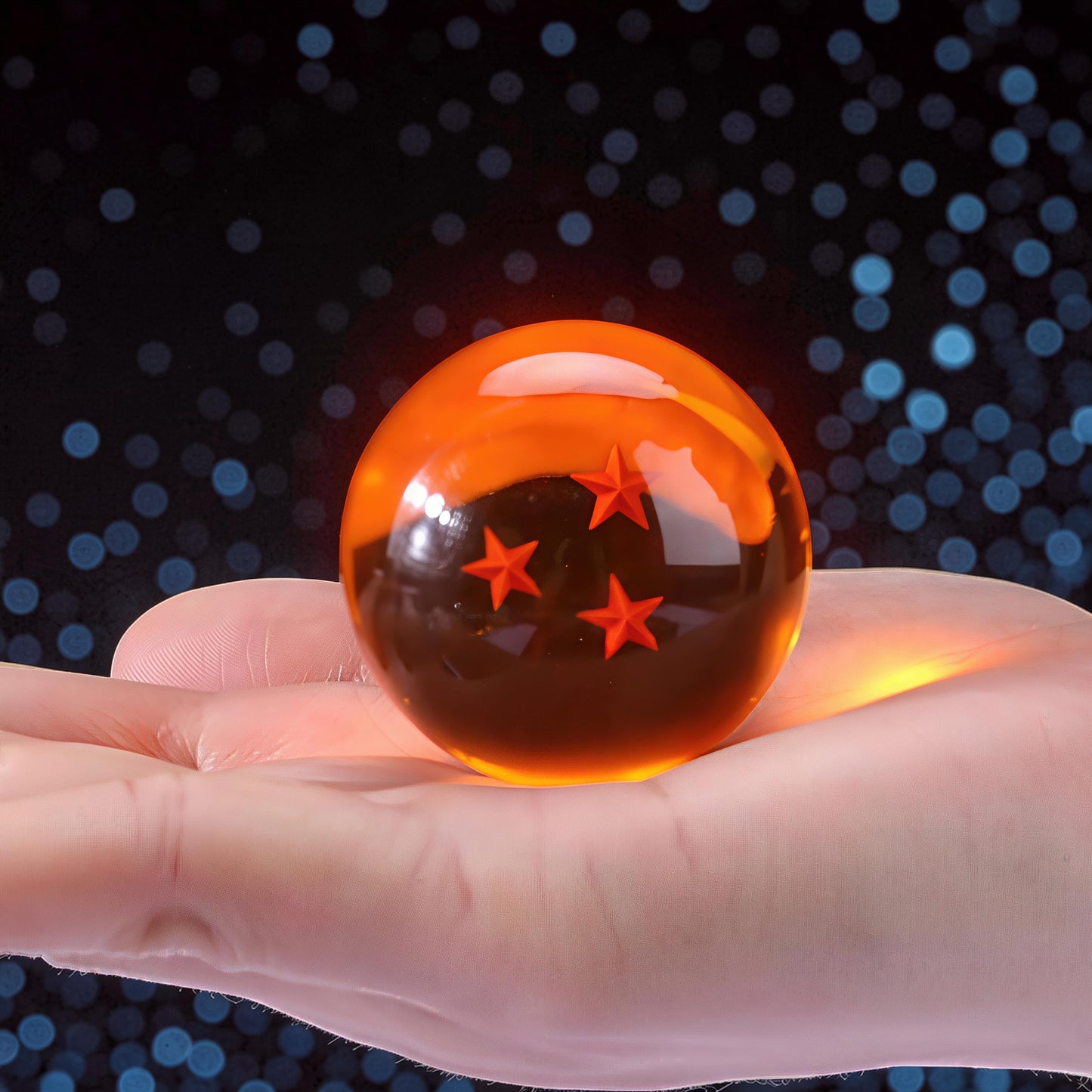 The Curious Mind Dragon Ball crystal ball with 4 orange stars inside, held in a hand. Made of crystal resin and metal.