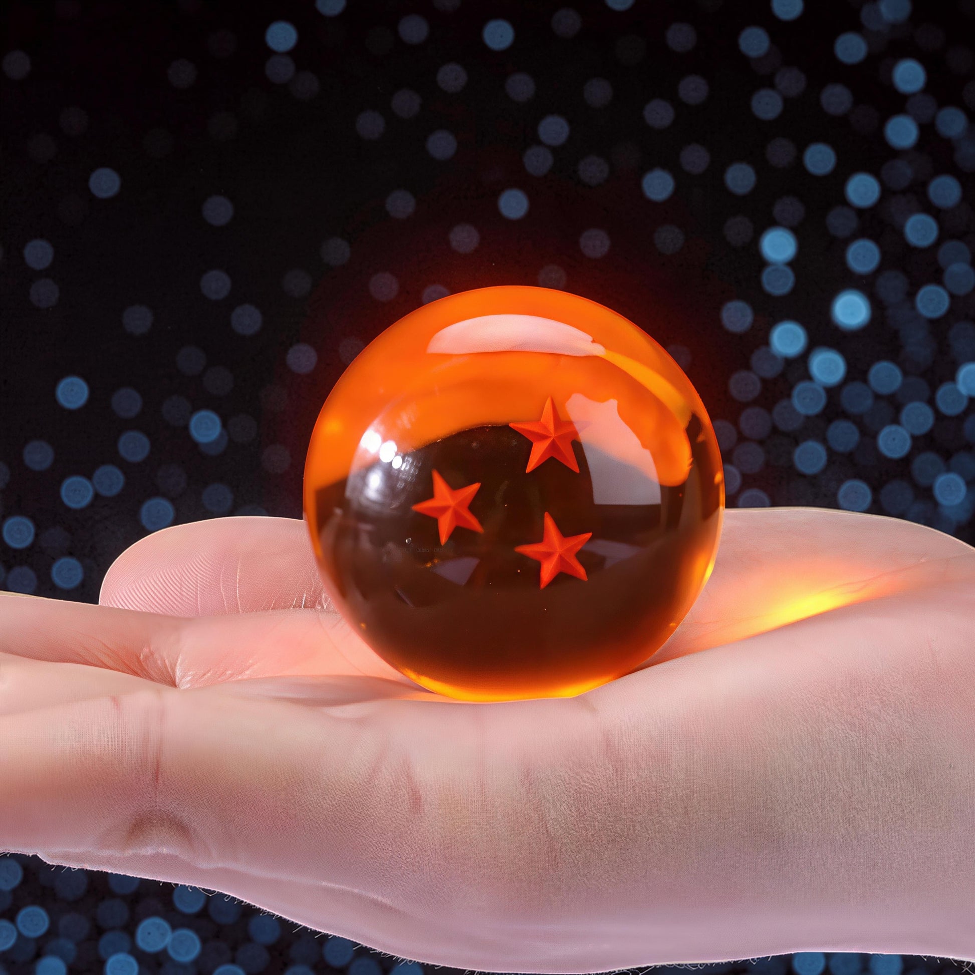 The Curious Mind Dragon Ball crystal ball with 4 orange stars inside, held in a hand. Made of crystal resin and metal.