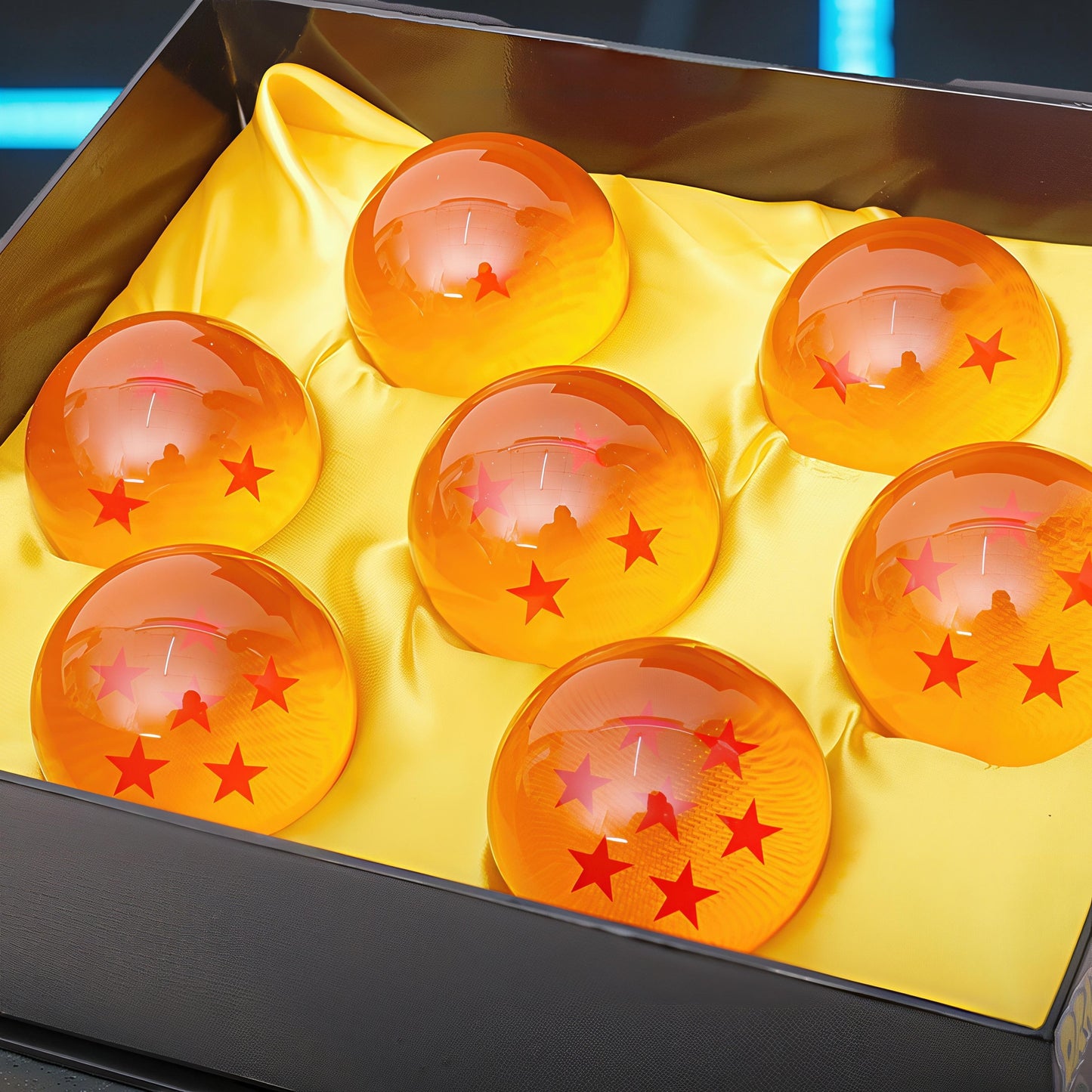 The Curious Mind Dragon Ball crystal balls with red stars inside, displayed in a black box on yellow satin.