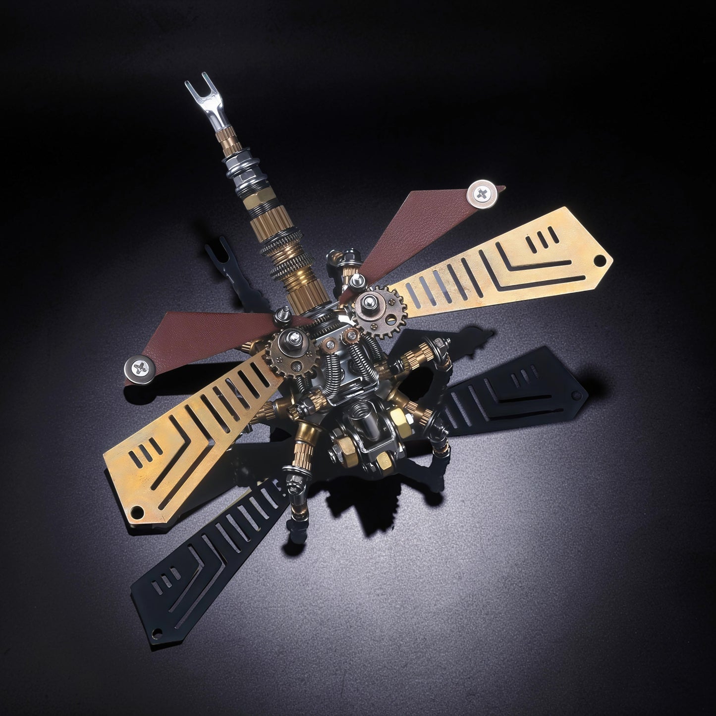 The Curious Mind Dragonfly 3D metal model kit with brass, steel, and leather accents. Intricate gears and mechanical details.