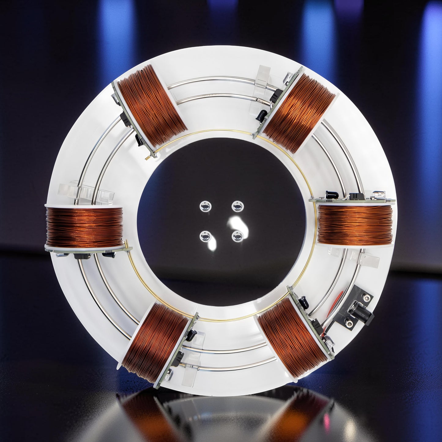 The Curious Mind High-Tech Electromagnetic Coil Accelerator Display, a white circular metal and acrylic science toy with copper coils.