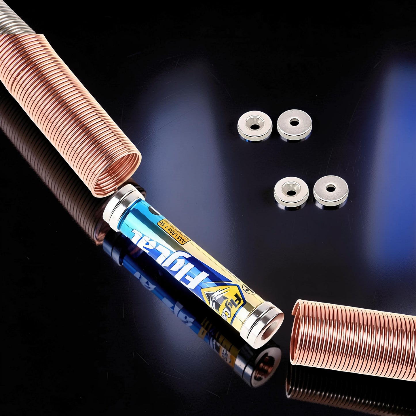 The Curious Mind Electromagnetic Train Puzzle Toy with copper coils, battery, and magnetic rings on a reflective black surface.