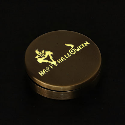 The Curious Mind Evil Pumpkin Haptic Coin Spinner, a bronze metal fidget toy with a yellow "Happy Halloween" design and a ghost graphic.
