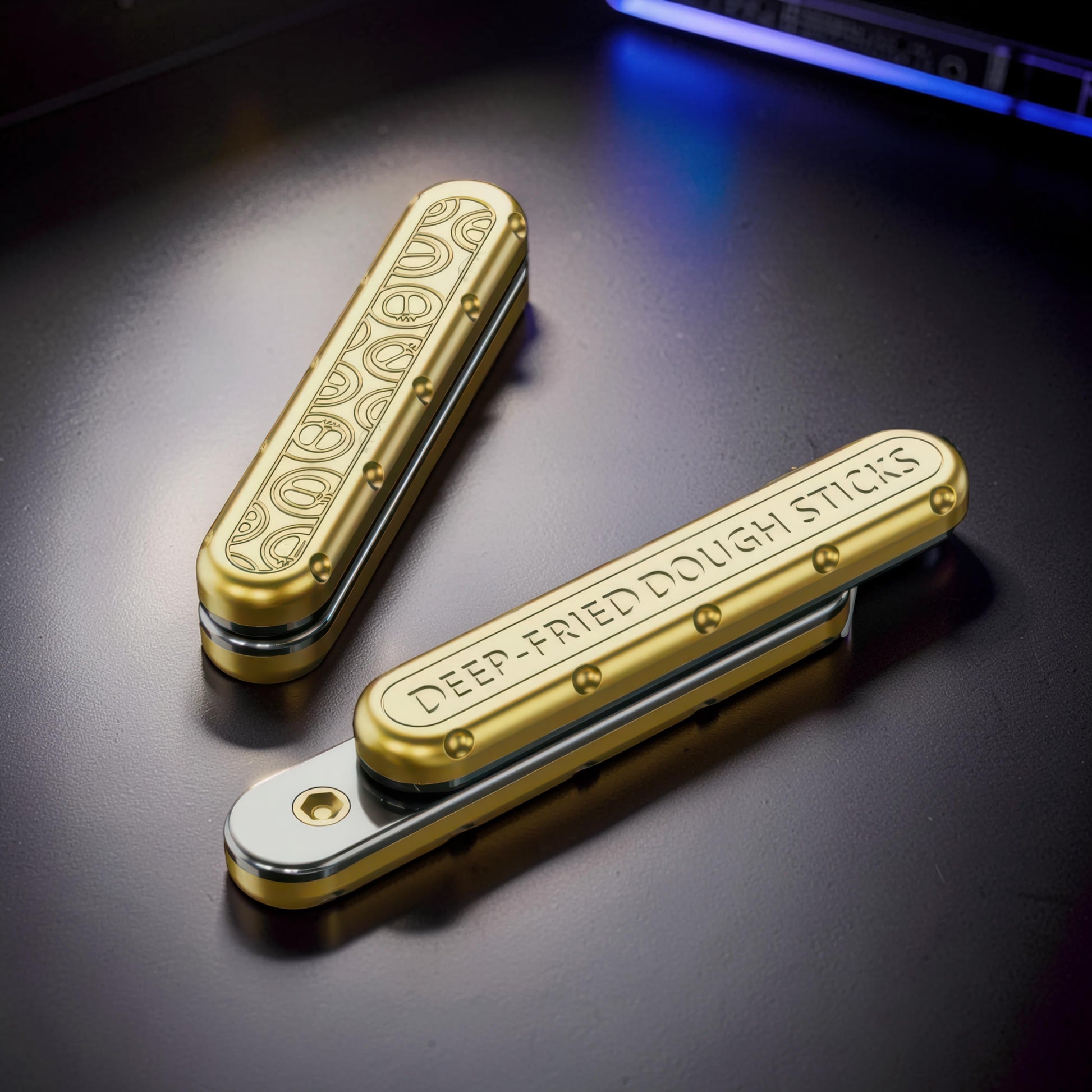 The Curious Mind Deep-Fried Dough Stick magnetic slider fidget toy, gold metal bar design with engraved pretzel pattern and text.