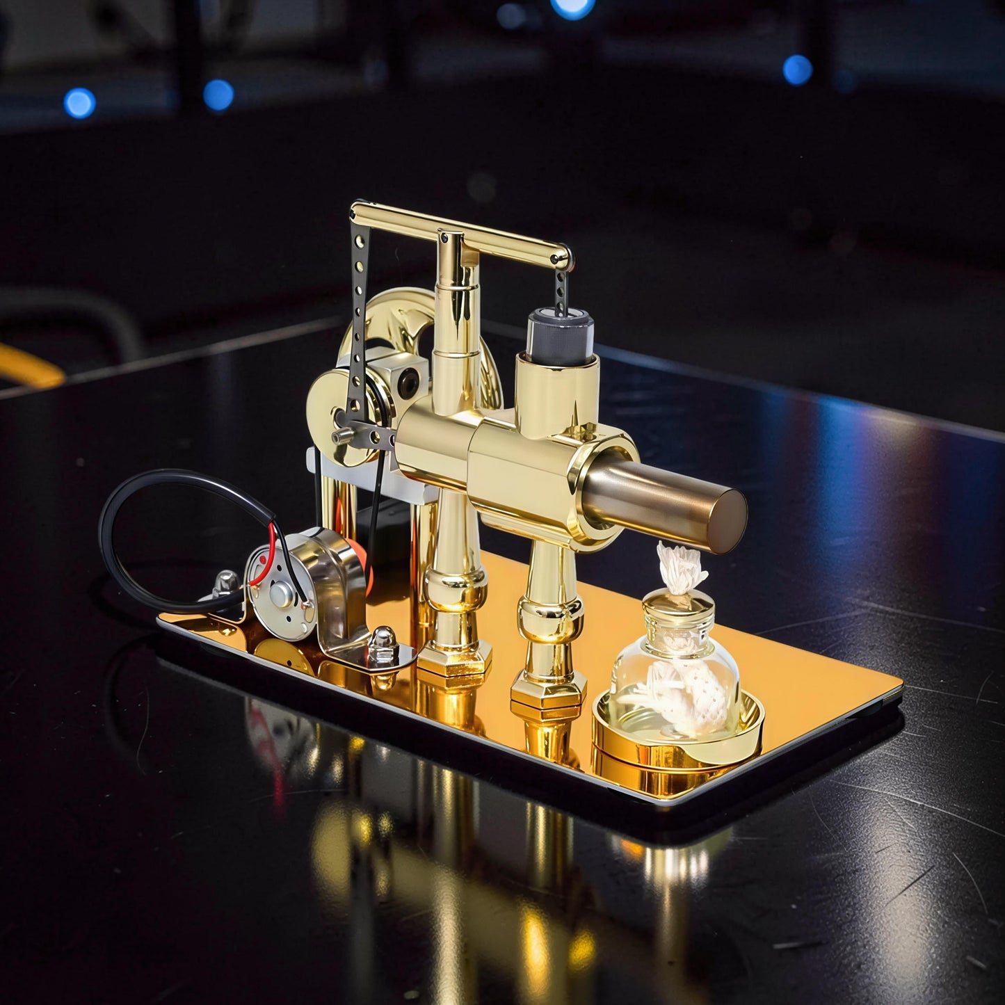The Curious Mind Stirling Engine Model, a polished gold metal mechanical model with power generation and LED light, displayed on a reflective base.