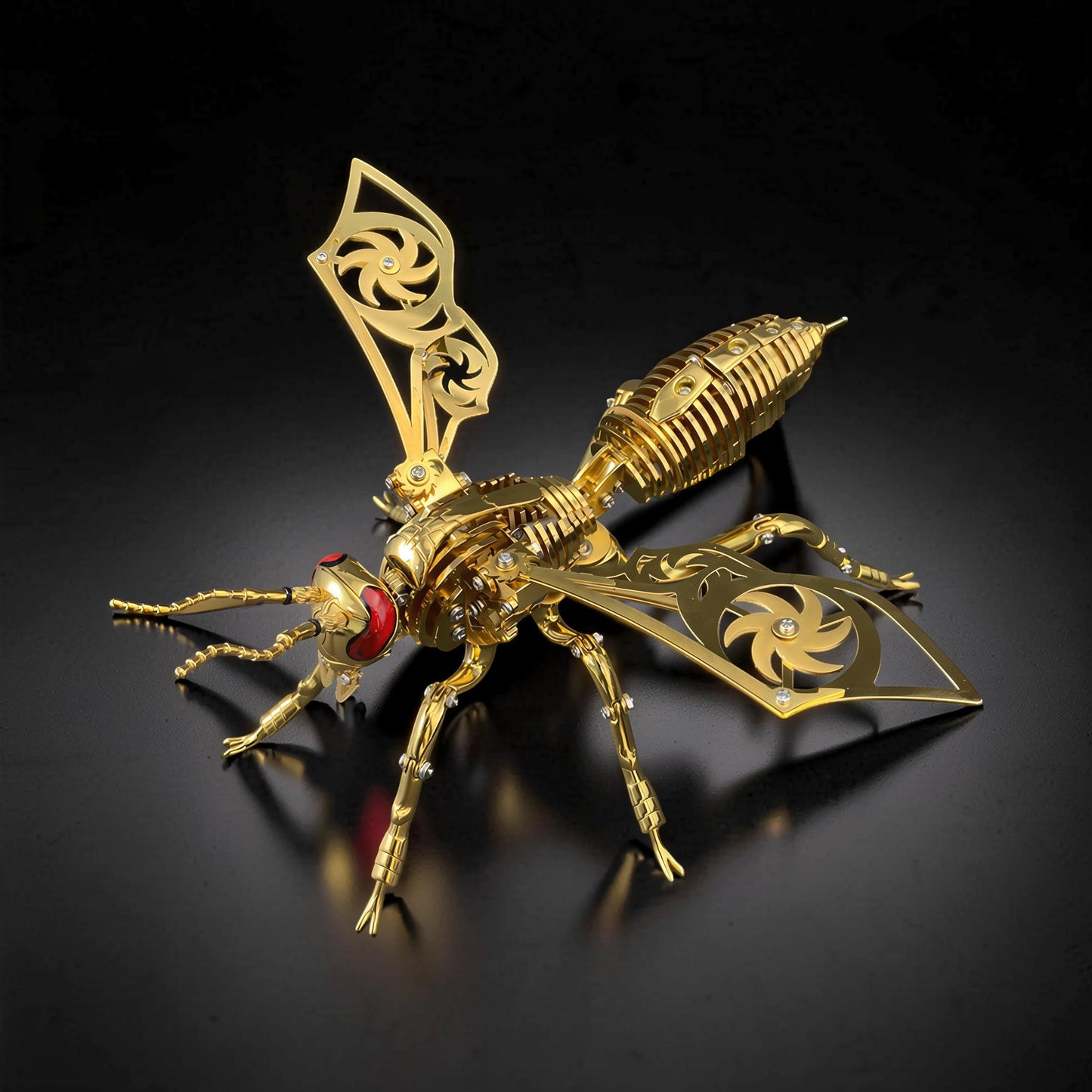 The Curious Mind Stainless Wasp 3D metal model kit, gold finish with intricate mechanical details and red eyes.
