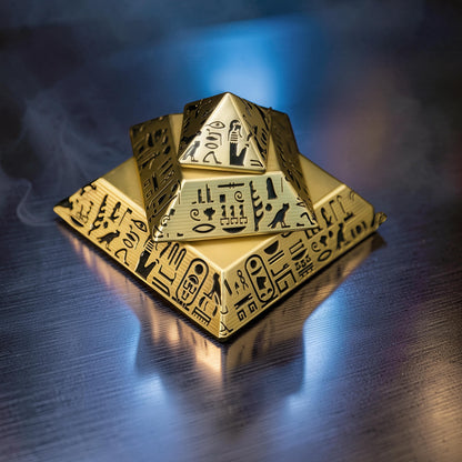 The Curious Mind gold-tone pyramid desk spinner with Egyptian hieroglyphs. Decorative and functional desk accessory.
