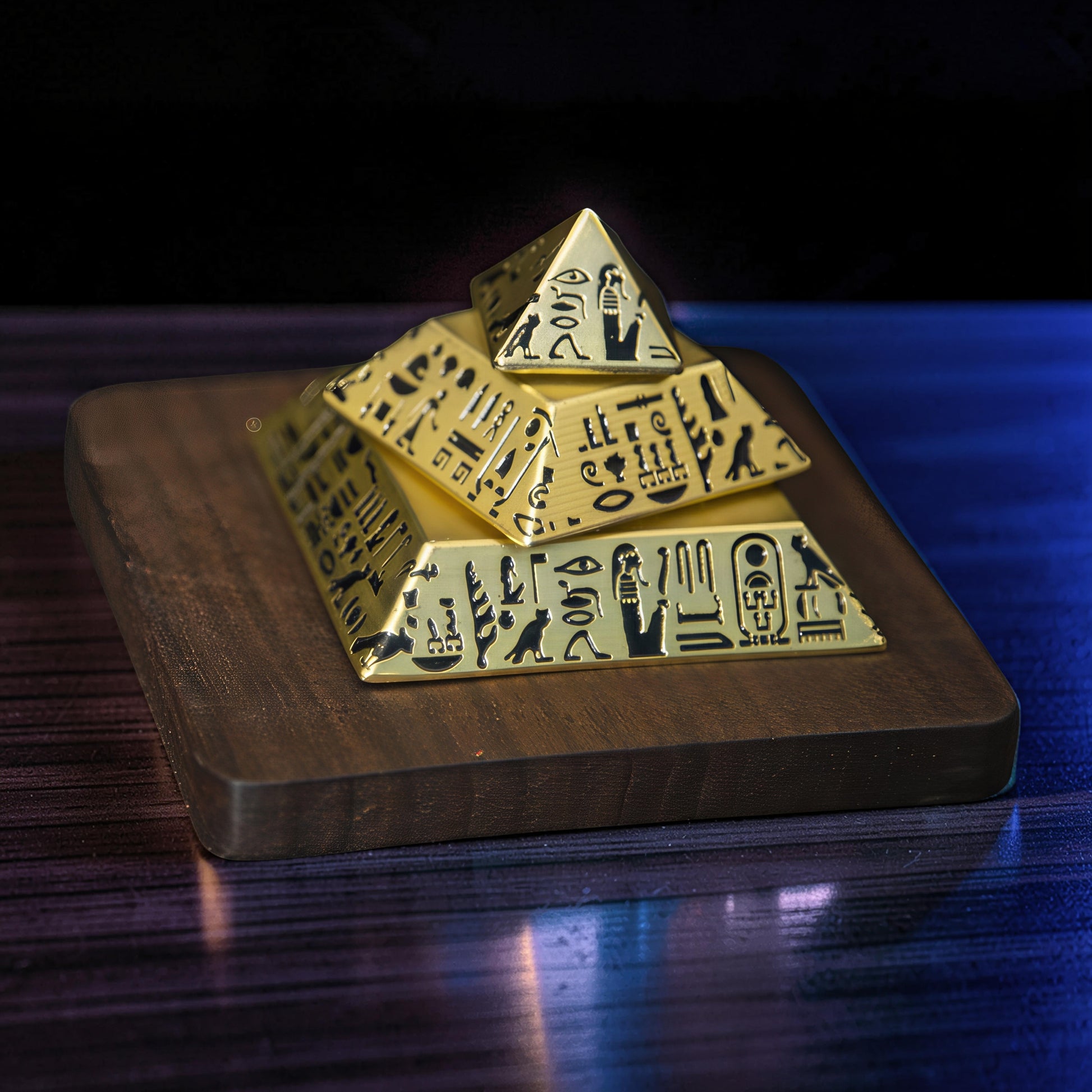 The Curious Mind gold pyramid desk spinner with Egyptian hieroglyphs on a wooden base.