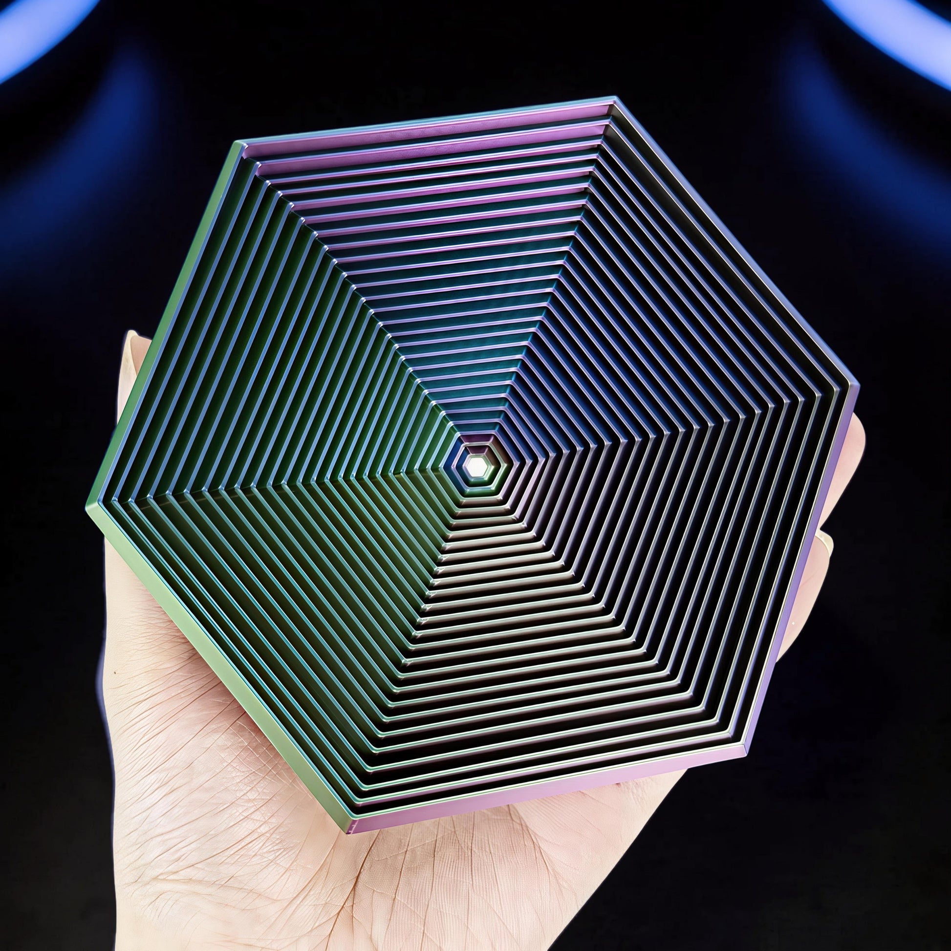 The Curious Mind Hexagon Push Fidget sensory toy with iridescent finish, held in a hand.