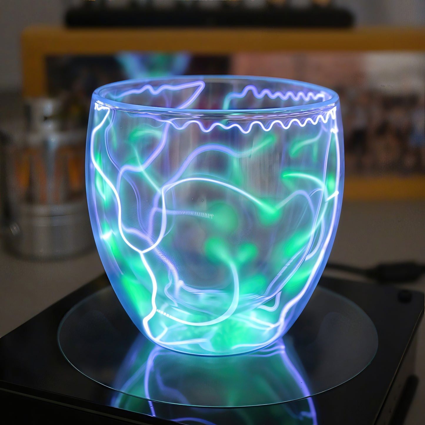 The Curious Mind Inert Gas Lightning Cup with display base, featuring swirling blue and green plasma arcs inside a clear glass vessel.