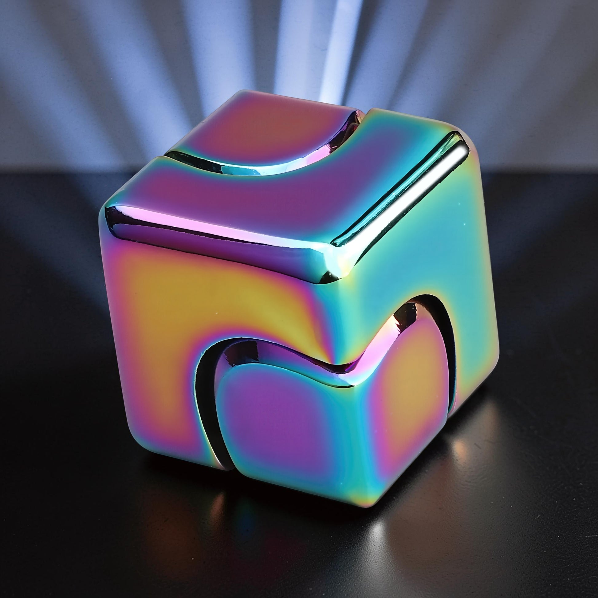 The Curious Mind Iridescent Spinner Cube, a compact metal fidget toy with a rainbow metallic finish and geometric design.