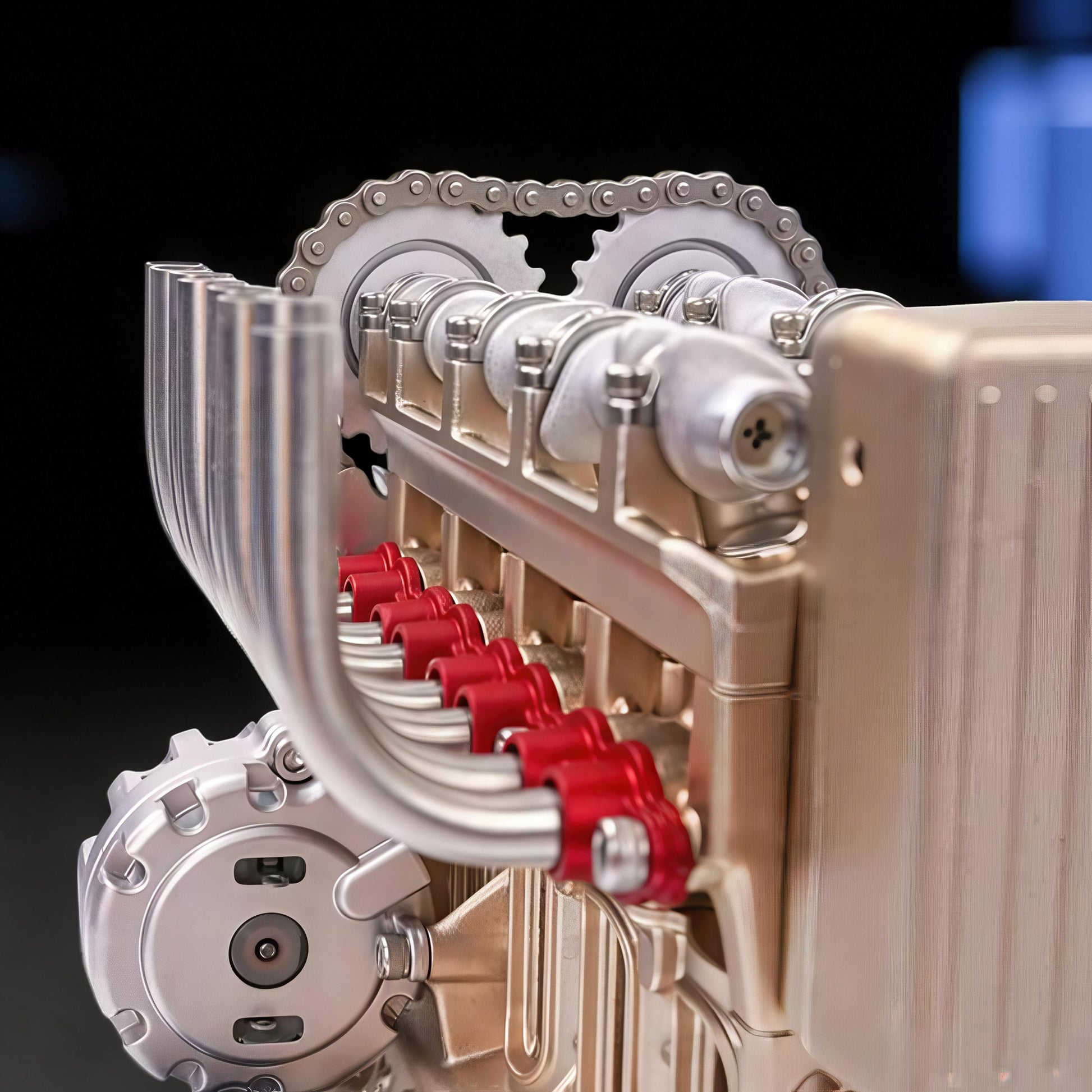 The Curious Mind L4 four-cylinder engine model kit, a detailed metal mechanical model with red accents and a silver chain.