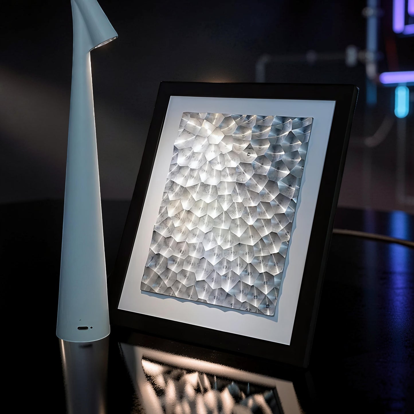 The Curious Mind laser light effect art frame with a textured silver surface and black frame, illuminated by internal lights.