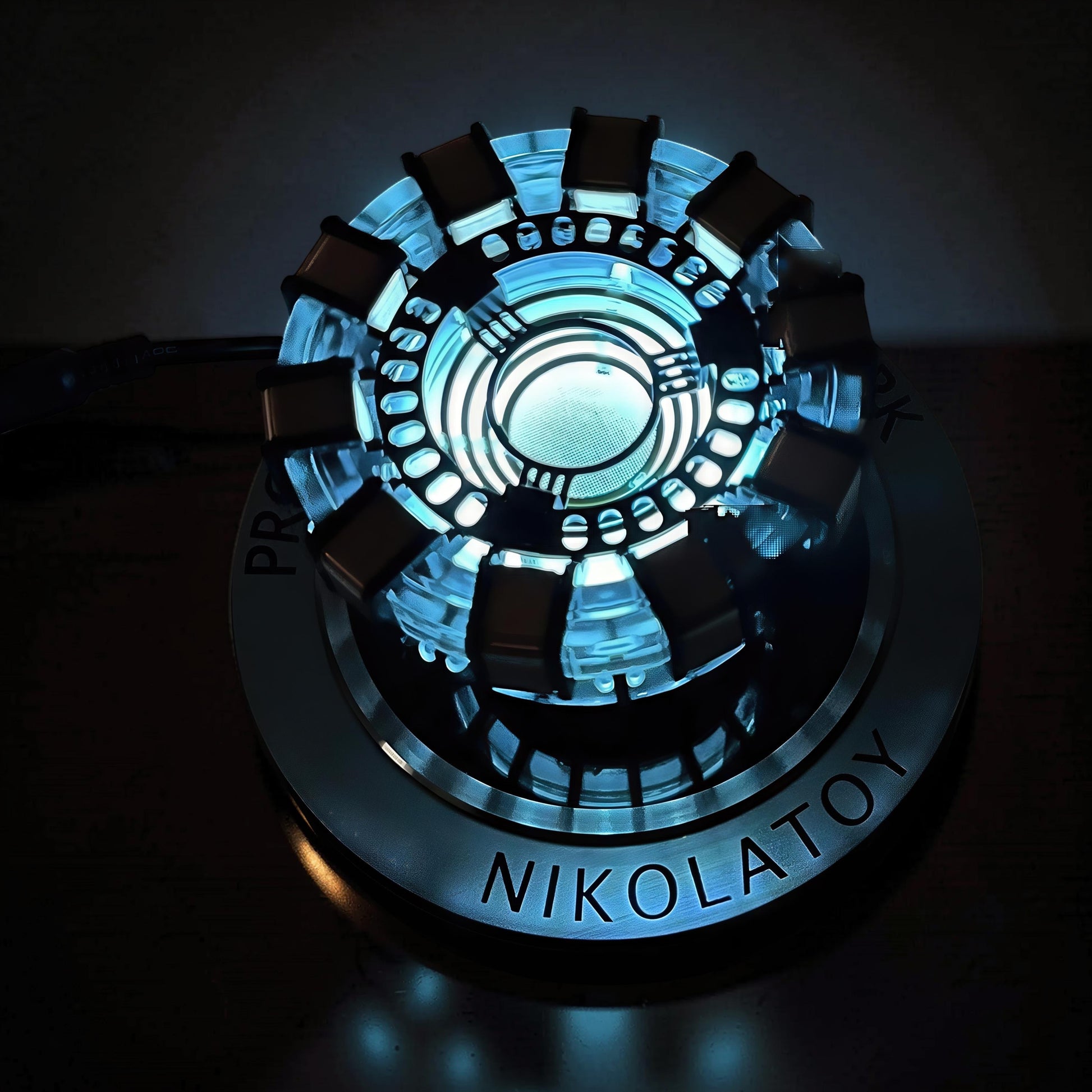 The Curious Mind Maglev Iron Man Ark Reactor Flagship HUD Edition, a metal desk object with blue glowing lights and a circular base.