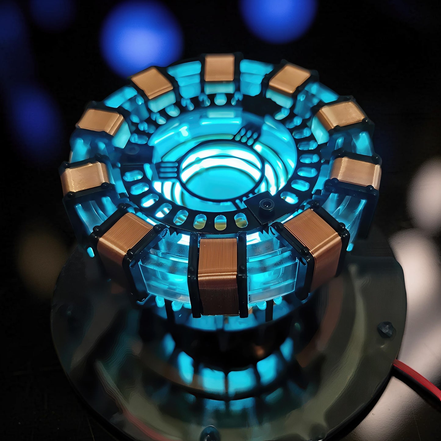 The Curious Mind Maglev Iron Man Ark Reactor Flagship HUD Edition, a metal desk object with glowing blue lights and copper coils.