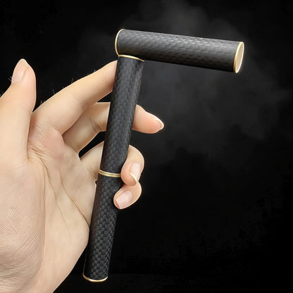 The Curious Mind Magnetic Carbon Fiber Slider fidget toy with gold accents, held in a hand against a black background.