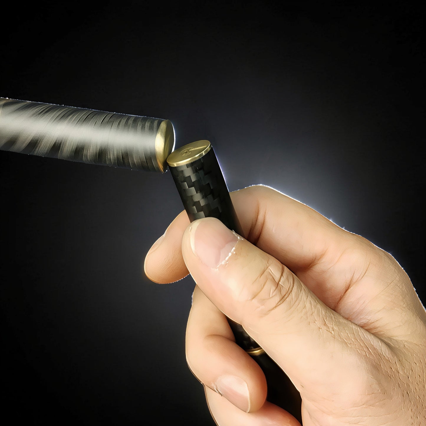 The Curious Mind Magnetic Carbon Fiber Slider fidget toy with gold accents, held in hand against a black background.