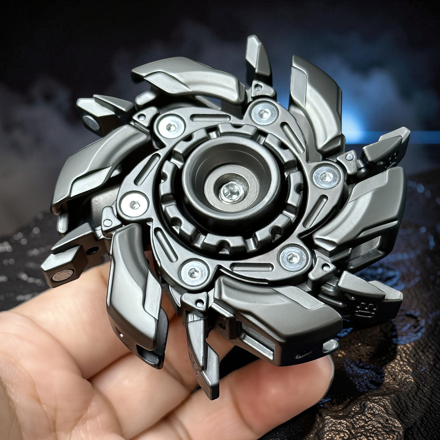 The Curious Mind Open Armour Magnetic Spinner, a metallic grey fidget toy with intricate mechanical details and magnetic accents, held in a hand.