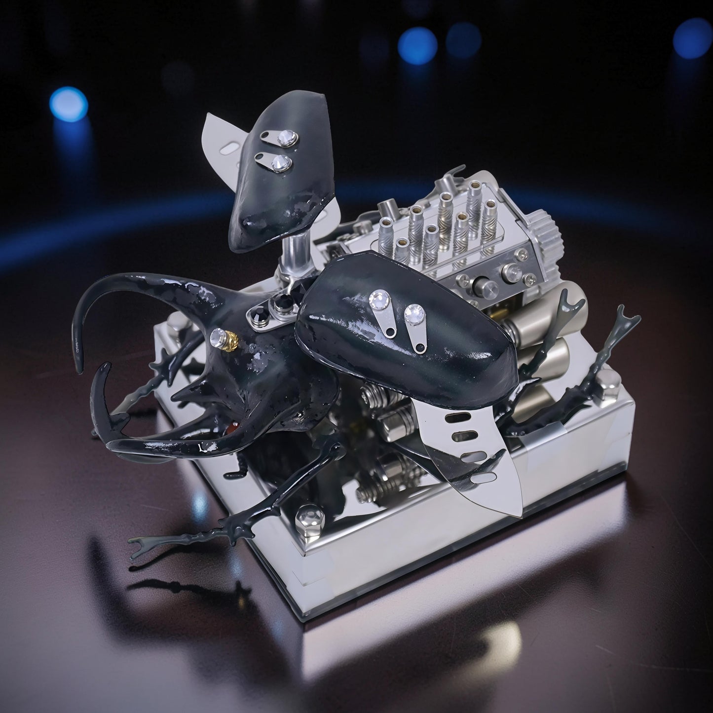 The Curious Mind Mechanical V8 Beetle Display Model, a detailed alloy metal and resin sculpture with black beetle features and intricate engine components.