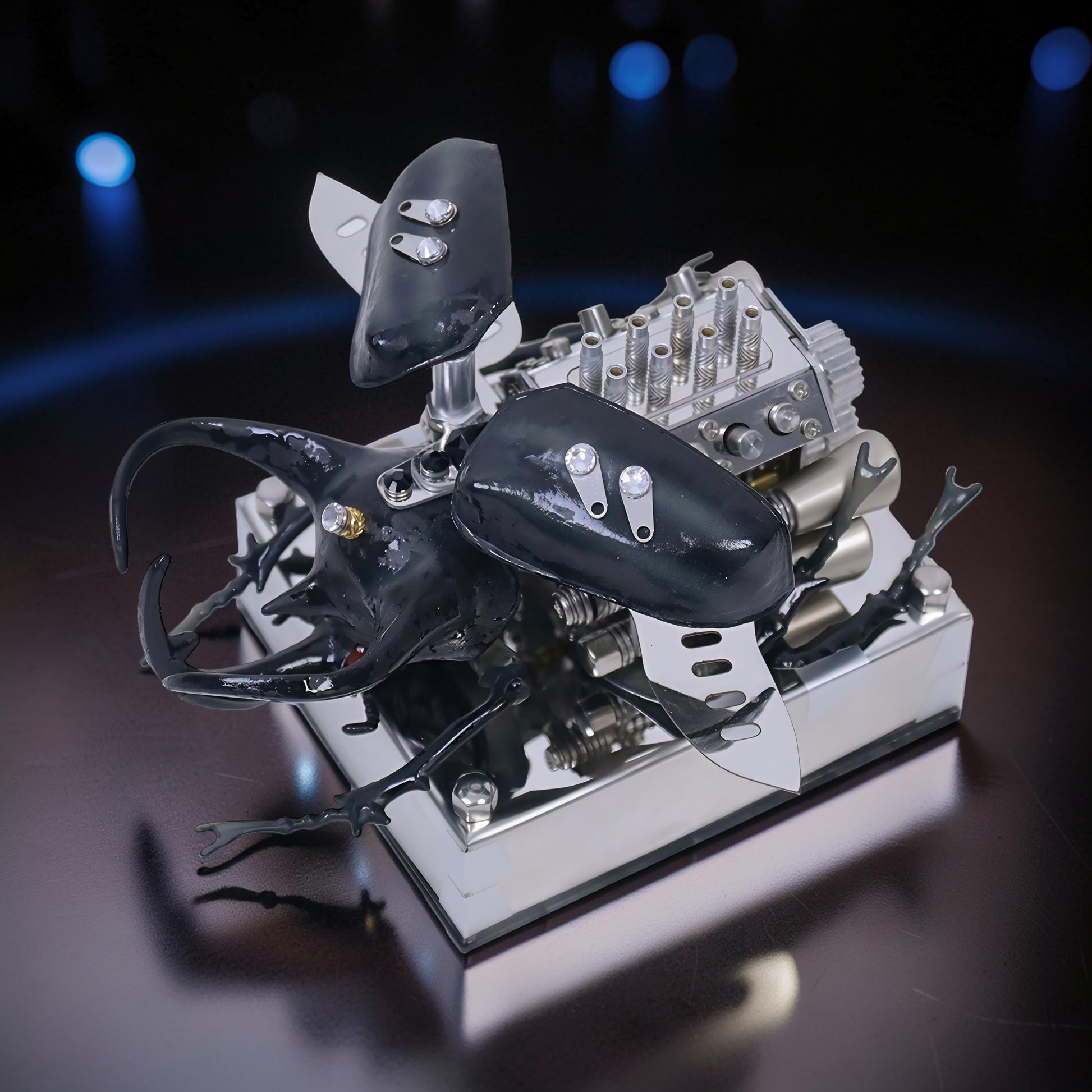 The Curious Mind Mechanical V8 Beetle Display Model, a detailed alloy metal and resin sculpture with black beetle features and intricate engine components.