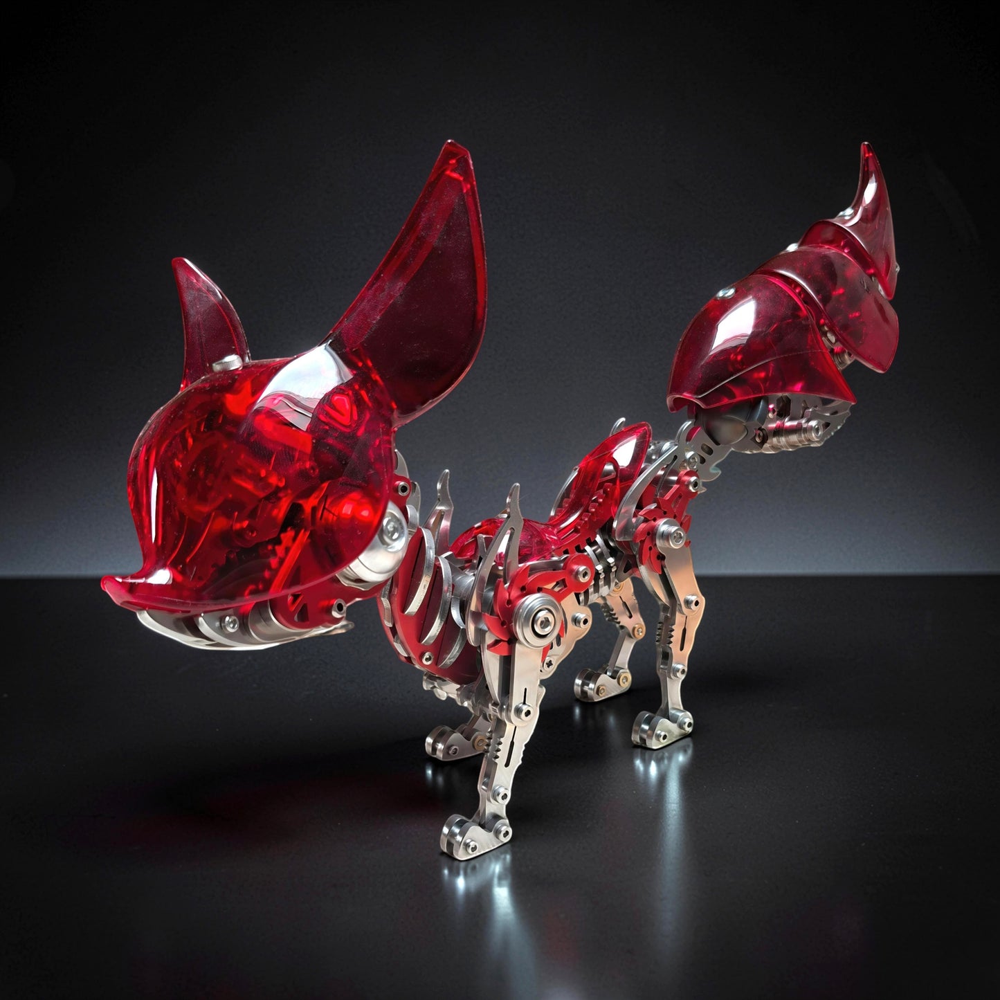 The Curious Mind Mechanical Fox 3D metal model kit with translucent red acrylic and polished metal parts.