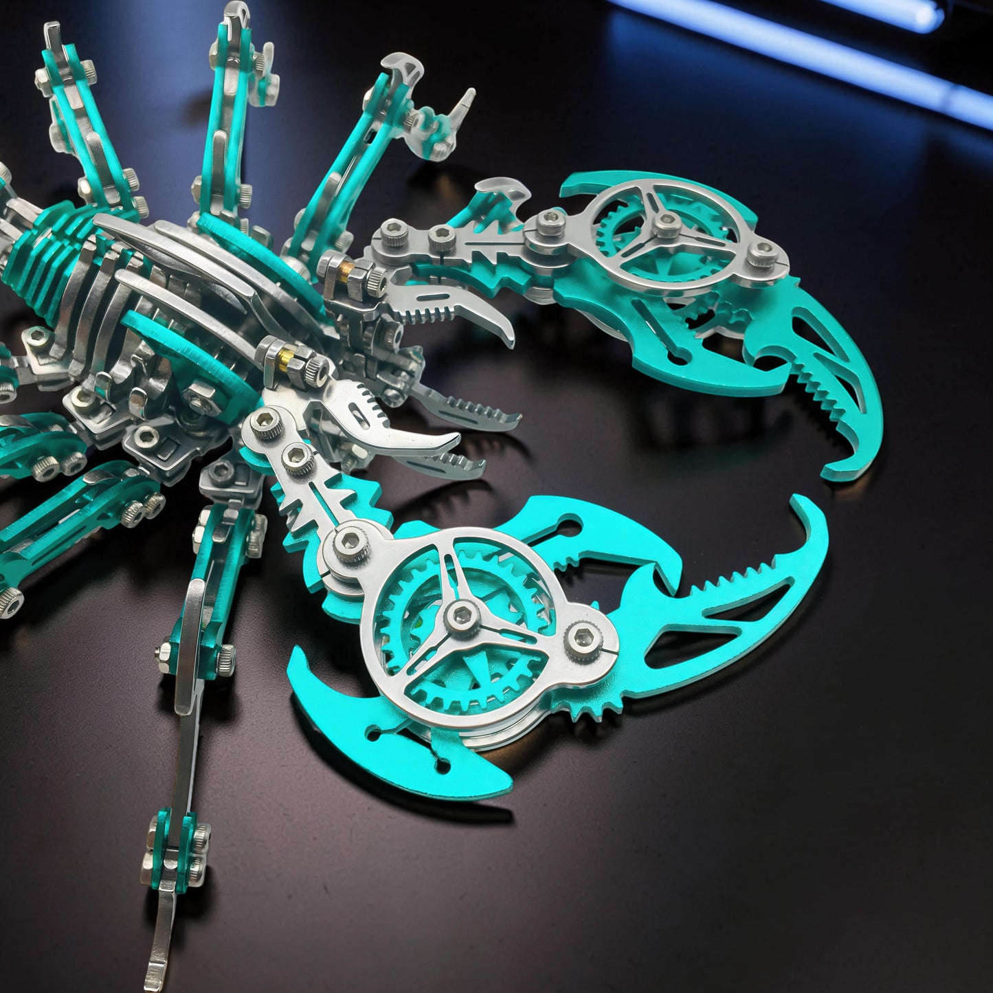 The Curious Mind Mechanical Scorpion 3D metal model kit with teal and silver metal parts, intricate gears, and articulated legs.