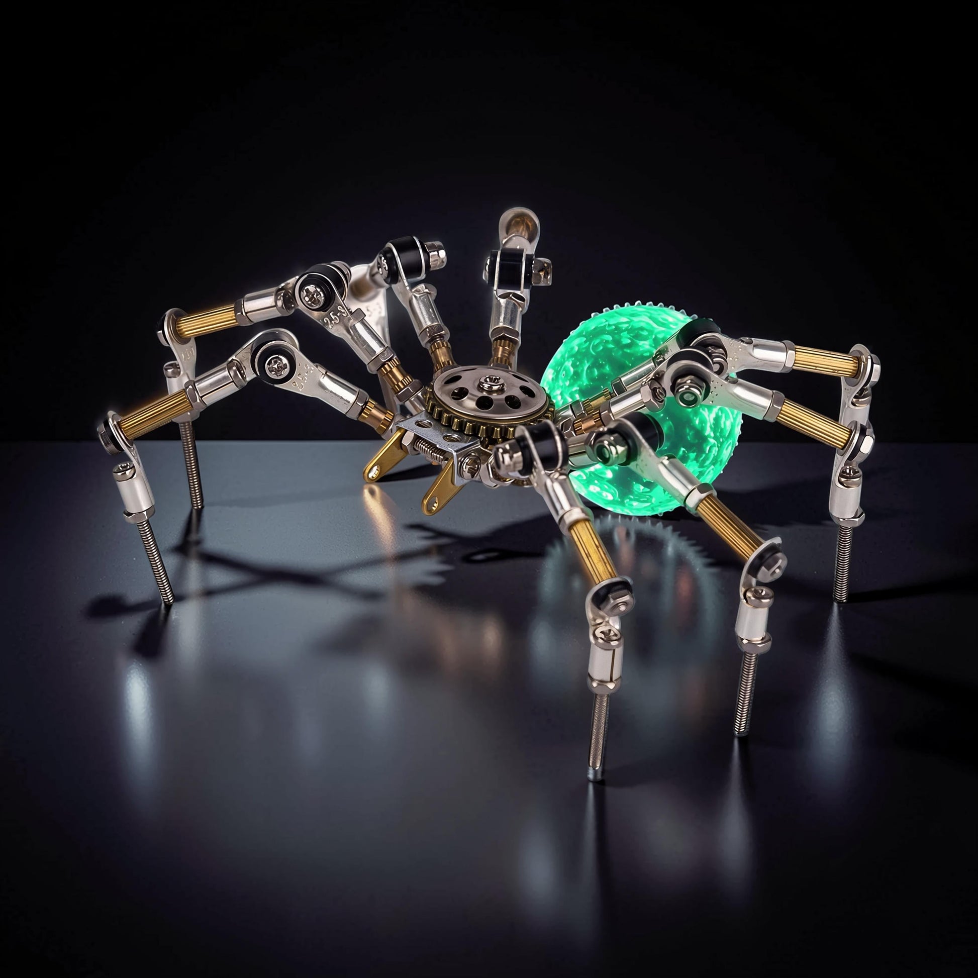 The Curious Mind Style G mechanical spider DIY kit, made of metal with a glowing green orb abdomen.