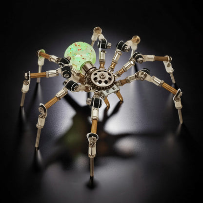 The Curious Mind Style G mechanical spider DIY kit, made of metal with a glowing green orb body.