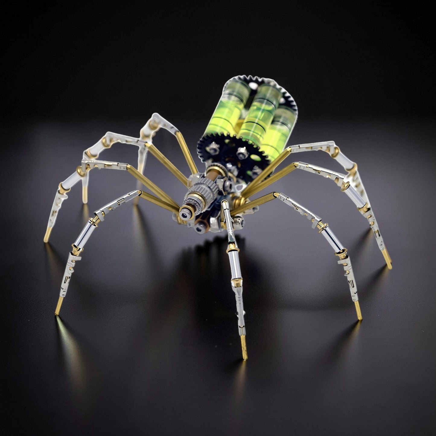 The Curious Mind mechanical spider DIY kit, a metal model with silver, gold, and green accents, featuring intricate gears and transparent tubes.
