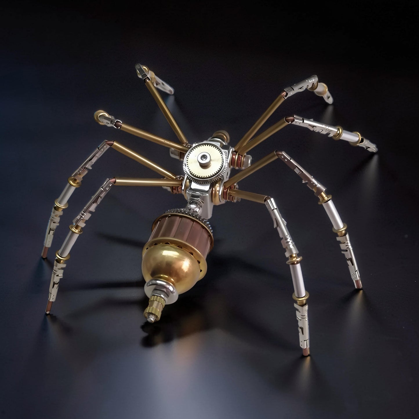 The Curious Mind Style C mechanical spider model kit, made of metal with brass and silver accents. Detailed gears and segmented legs.