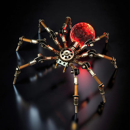 The Curious Mind Style G mechanical spider model kit, made of metal, with a red glowing orb.