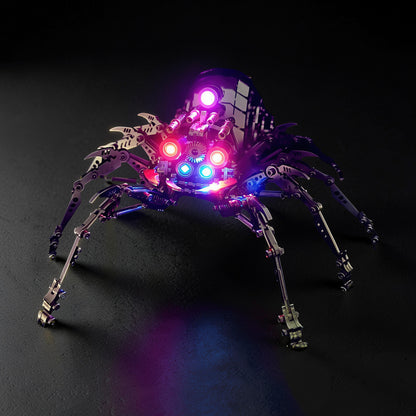 The Curious Mind Mechanical Spider 3D metal model kit with intricate metal parts and illuminated red, blue, and purple lights.