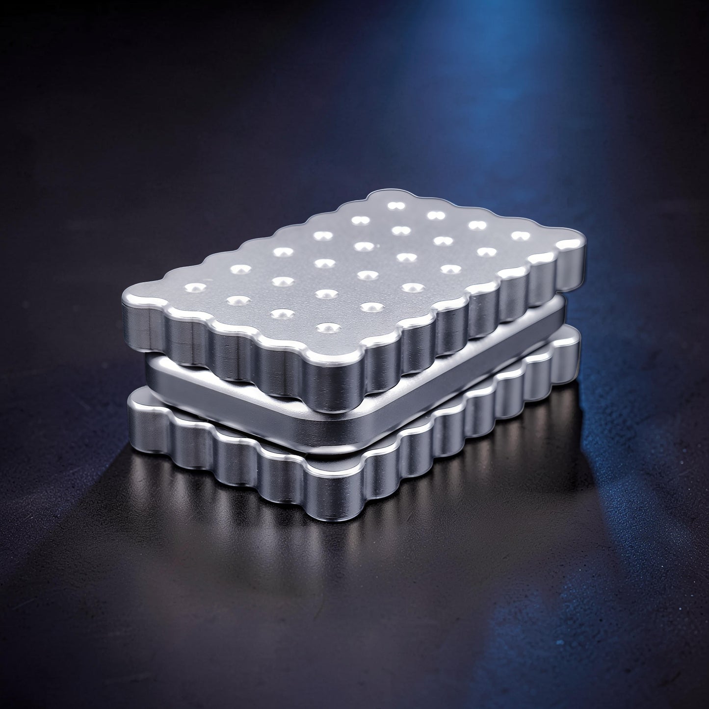 The Curious Mind Biscuit Push Card Slider, a compact silver metal fidget toy with a scalloped edge and textured top.