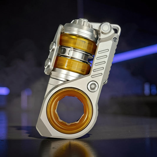 The Curious Mind Fork Ratchet Metal Slider fidget toy with silver metal casing and amber-colored internal components.