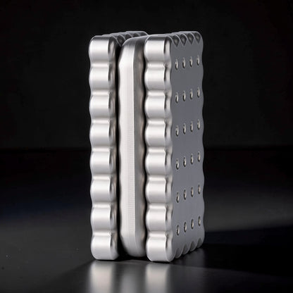 The Curious Mind Biscuit Push Card Slider, a compact metal fidget toy with a silver finish and textured edges, designed for tactile feedback and stress relief.