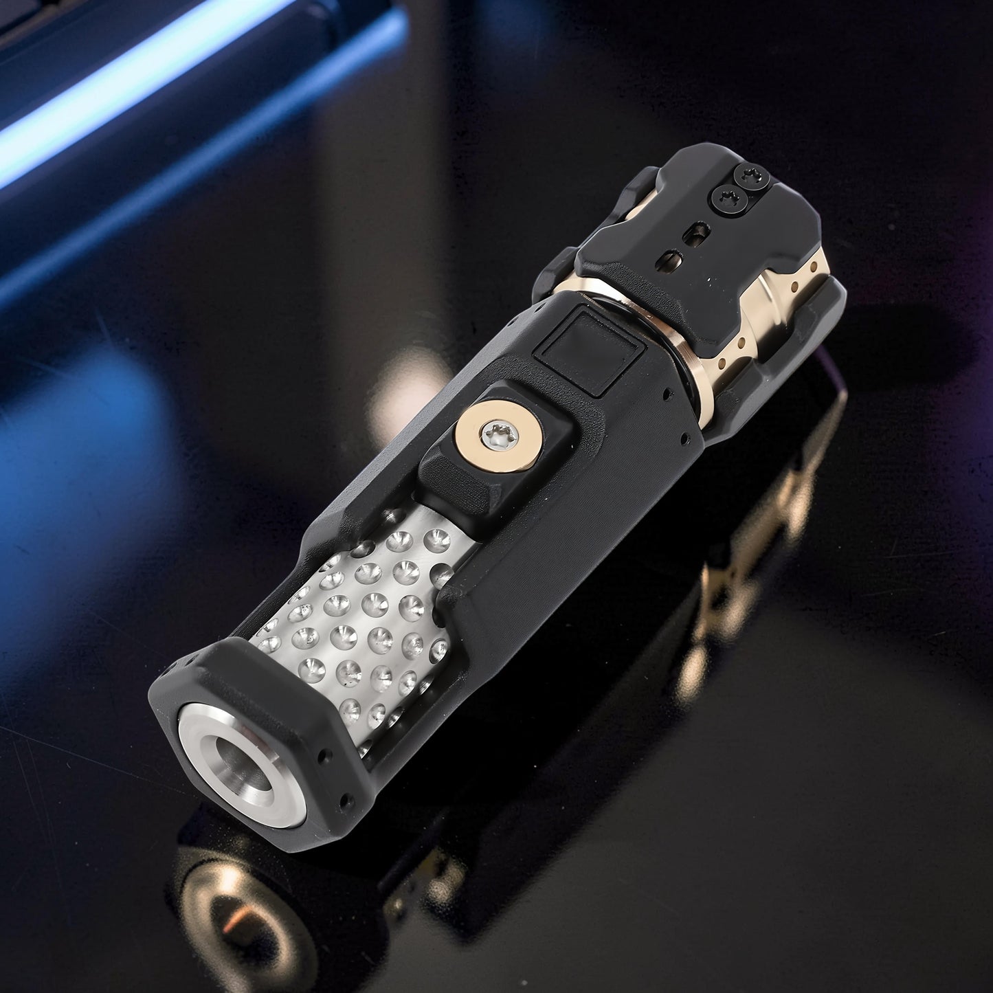 The Curious Mind Musketeers Snap Coin Clicker fidget toy in black metal with gold accents and a textured grip.