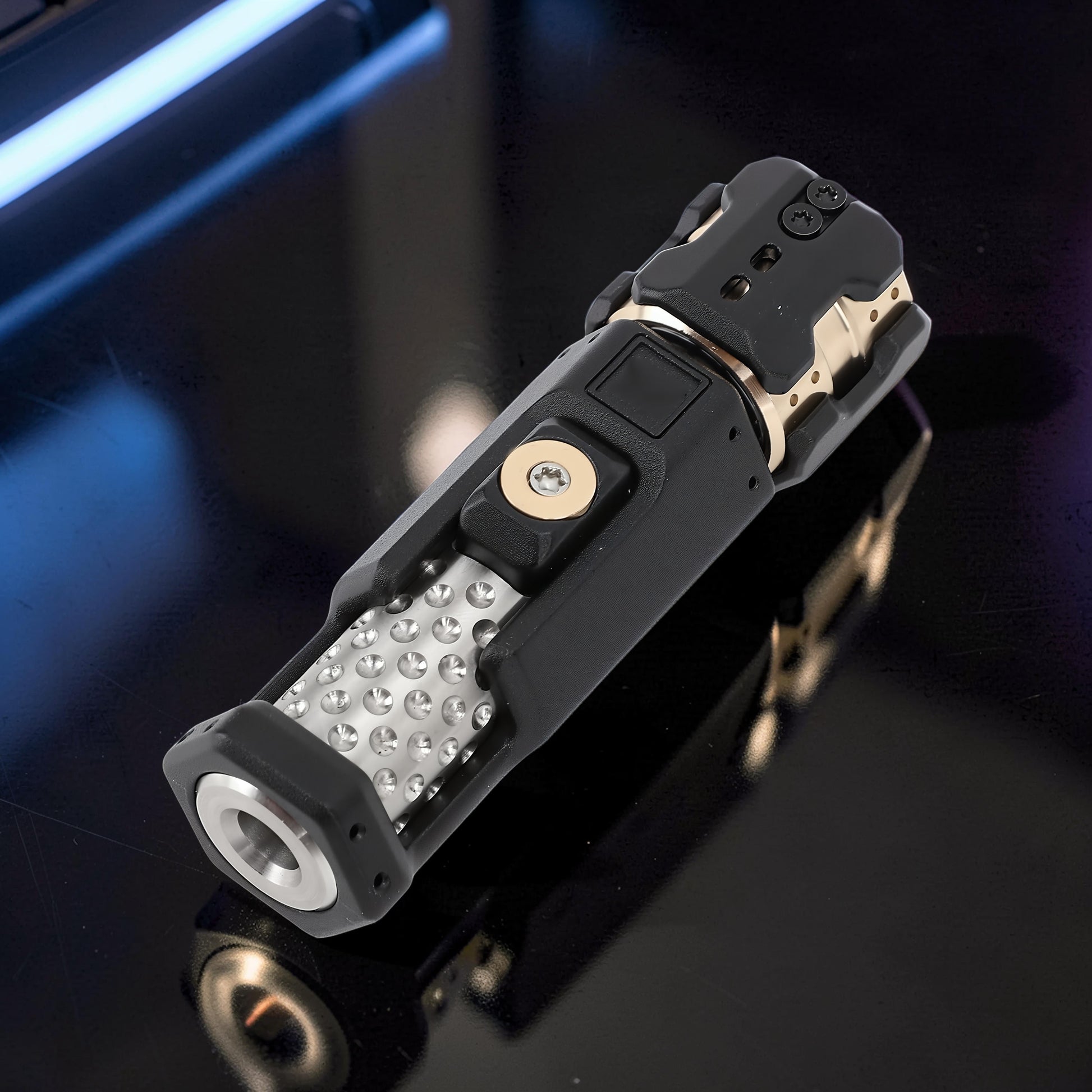 The Curious Mind Musketeers Snap Coin Clicker fidget toy in black metal with gold accents and a textured grip.