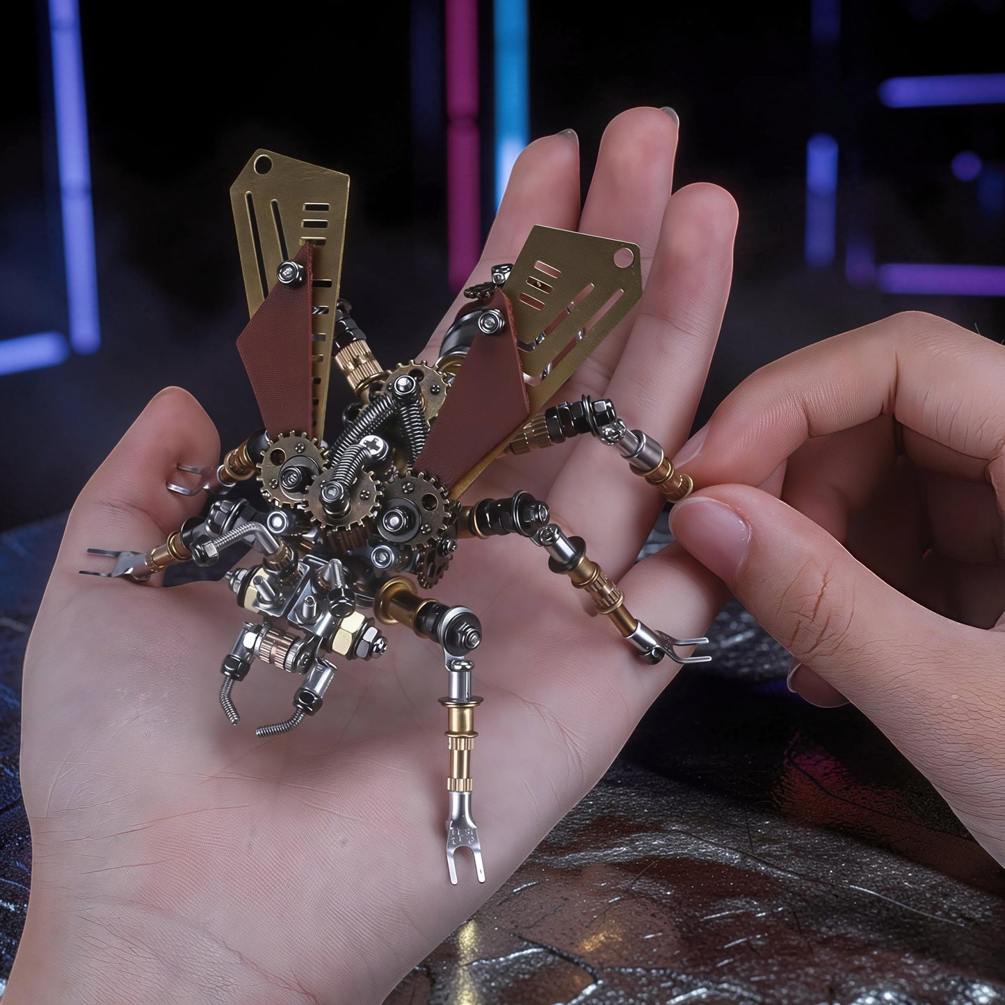 The Curious Mind Termite 3D metal model kit with intricate gears, brass wings, and metallic legs, held in a hand.