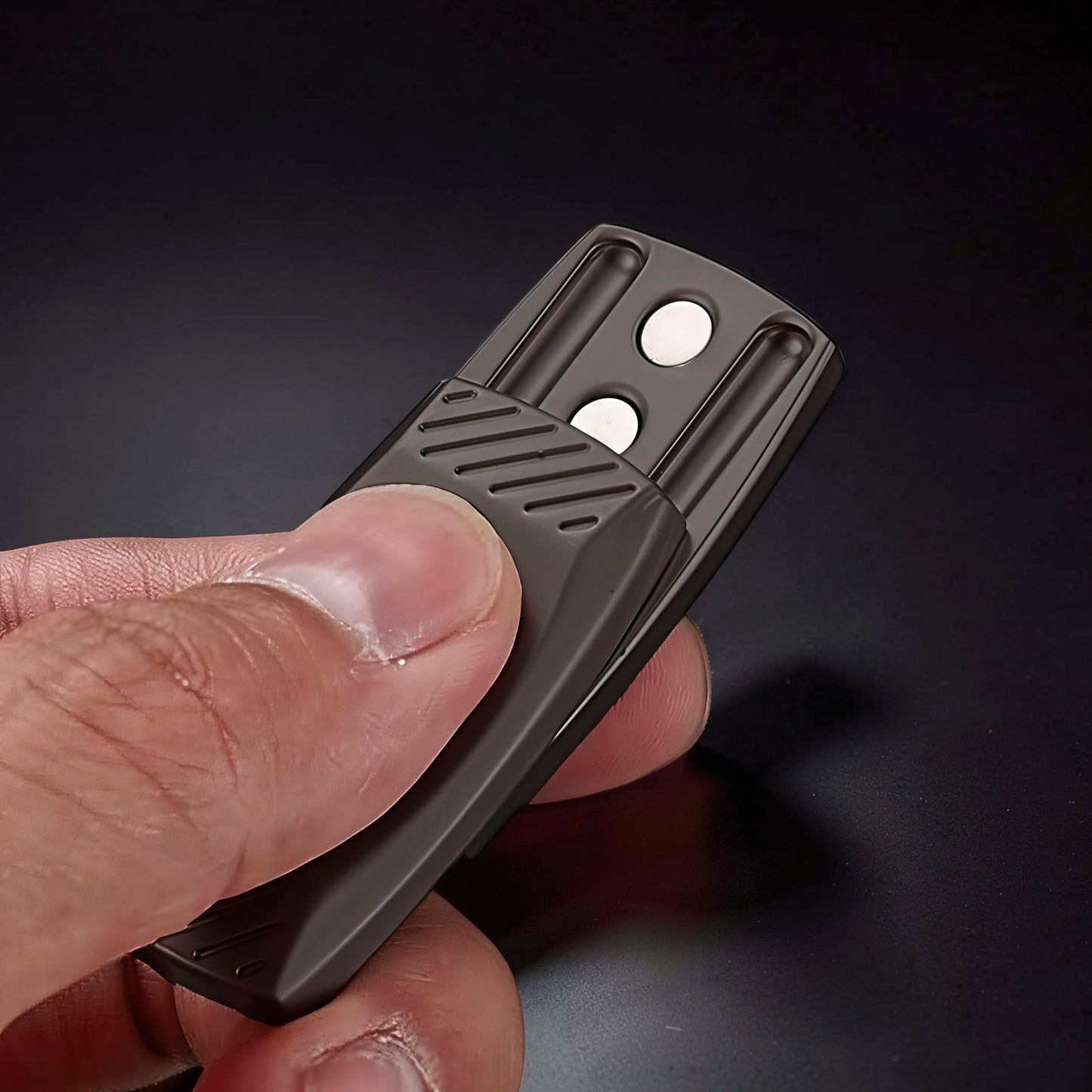 The Curious Mind Fingerprint Pattern Push Slider, a compact dark gray metal fidget toy with textured grip and two white magnetic sliders.