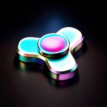 The Curious Mind Mini Elf Hand Spinner, a metallic fidget toy with iridescent blue and pink accents, designed for stress relief and focus.