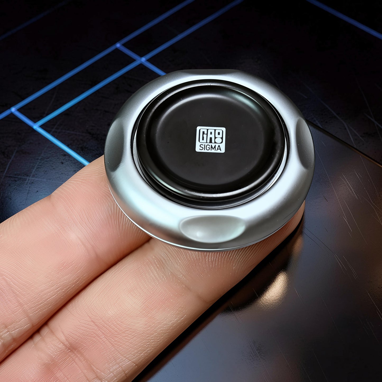 The Curious Mind Magnetic Master 2.0 metal spinner with black center and silver body, held in a hand.