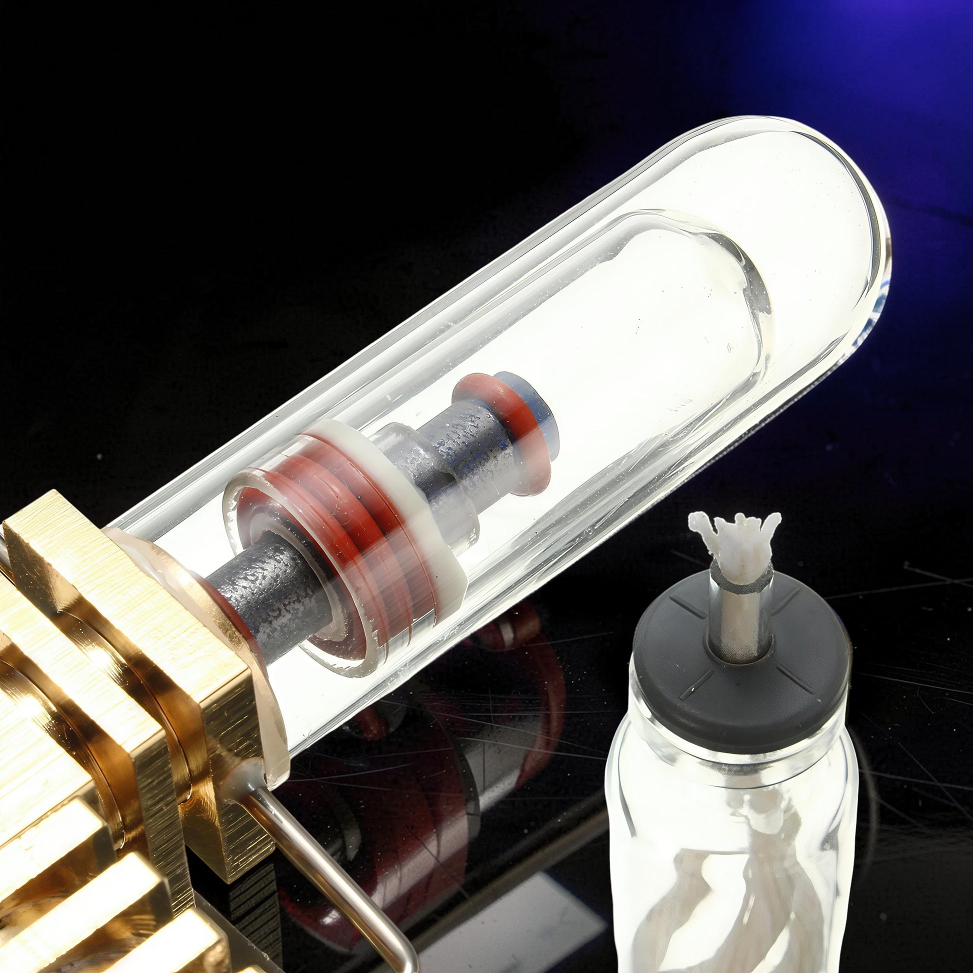 The Curious Mind Mini Aircraft Stirling Engine Display Model, made of metal and glass, with red and blue accents.