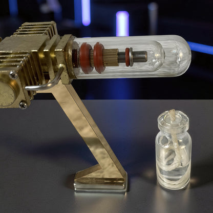 The Curious Mind Mini Aircraft Stirling Engine Display Model, a brass and glass mechanical model with red rubber seals and a glass fuel jar.