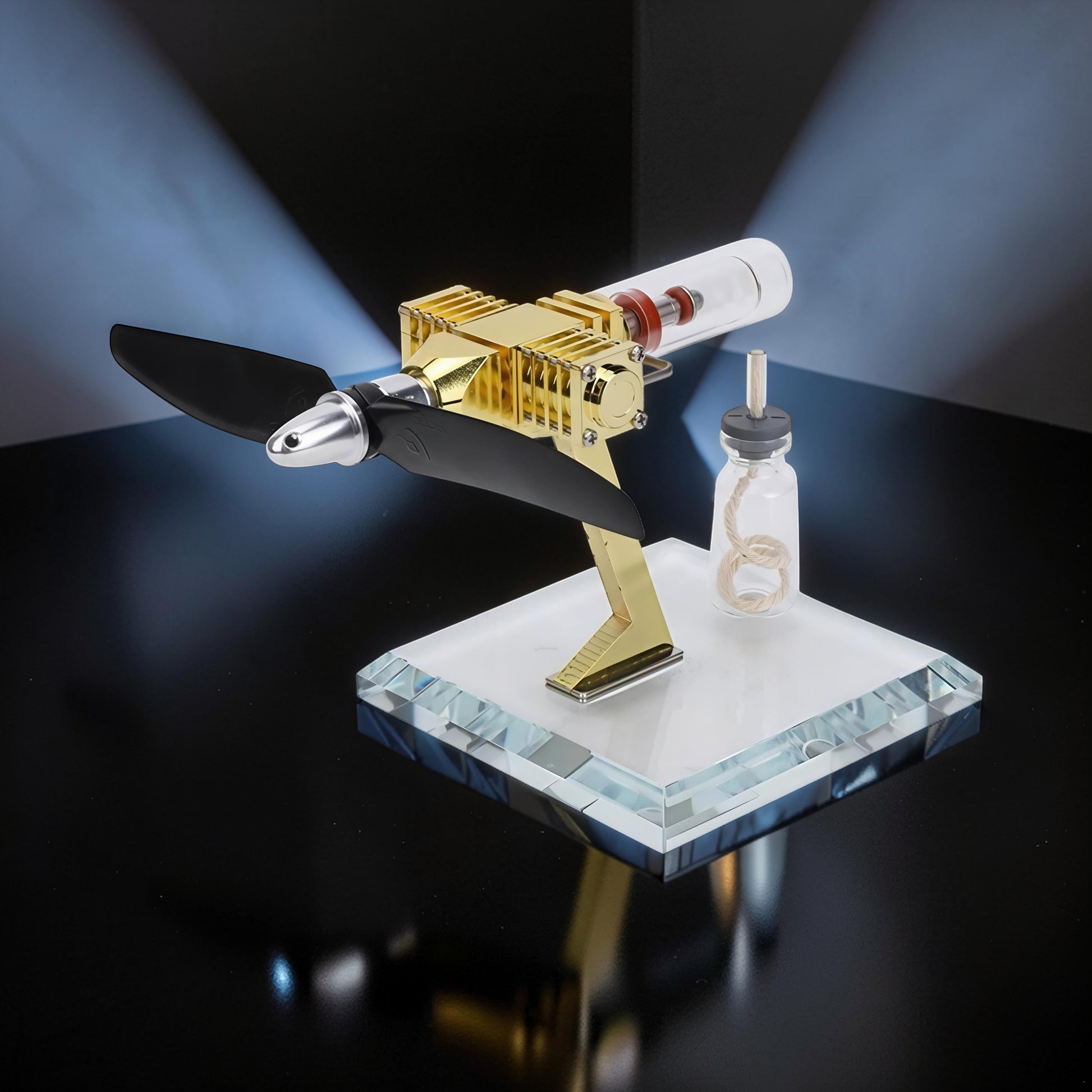 The Curious Mind Mini Aircraft Stirling Engine Display Model, gold metal engine with black propeller on a clear acrylic base.