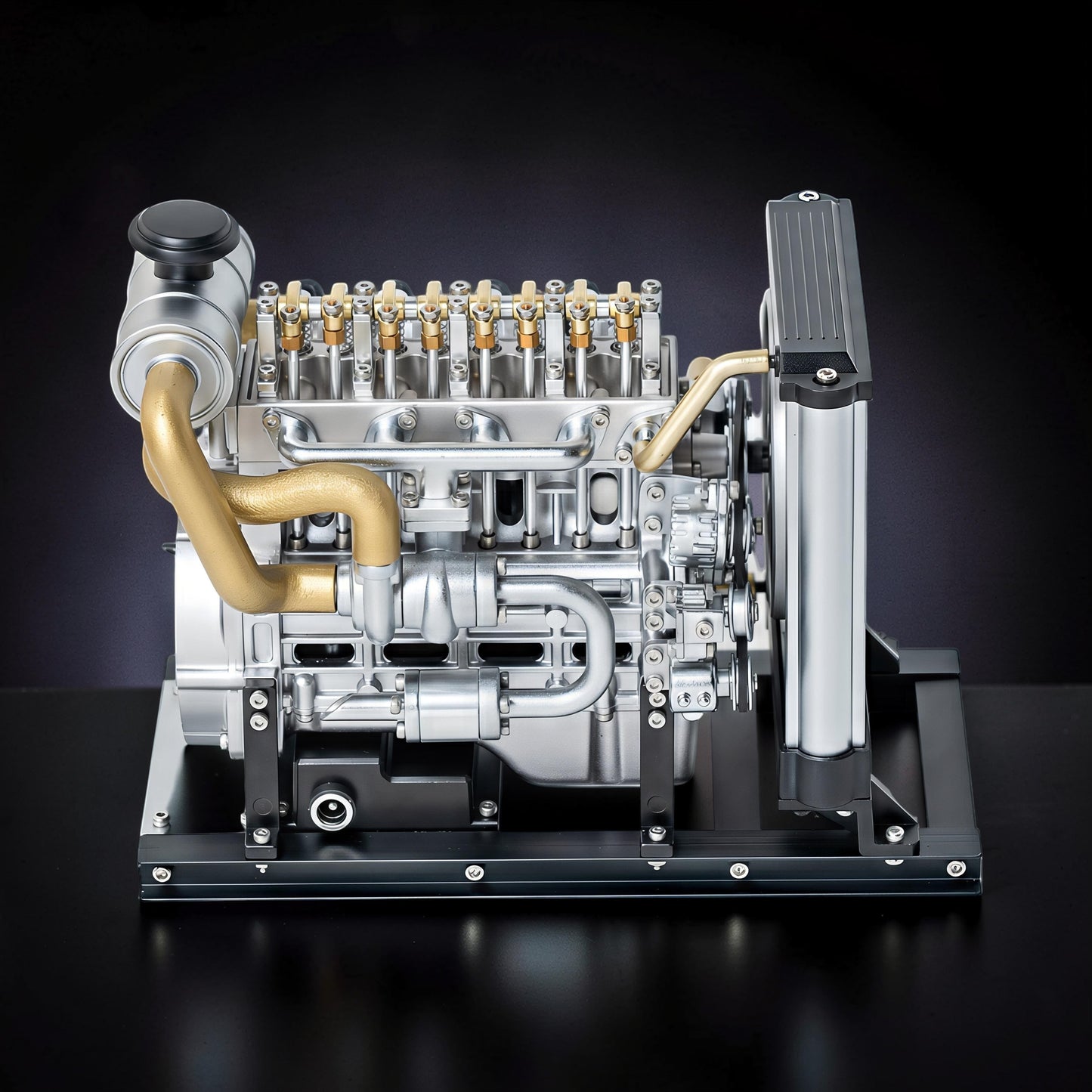 The Curious Mind Mini Diesel 4-Cylinder Engine DIY Kit, a detailed metal mechanical model with gold and silver accents, displayed on a black base.