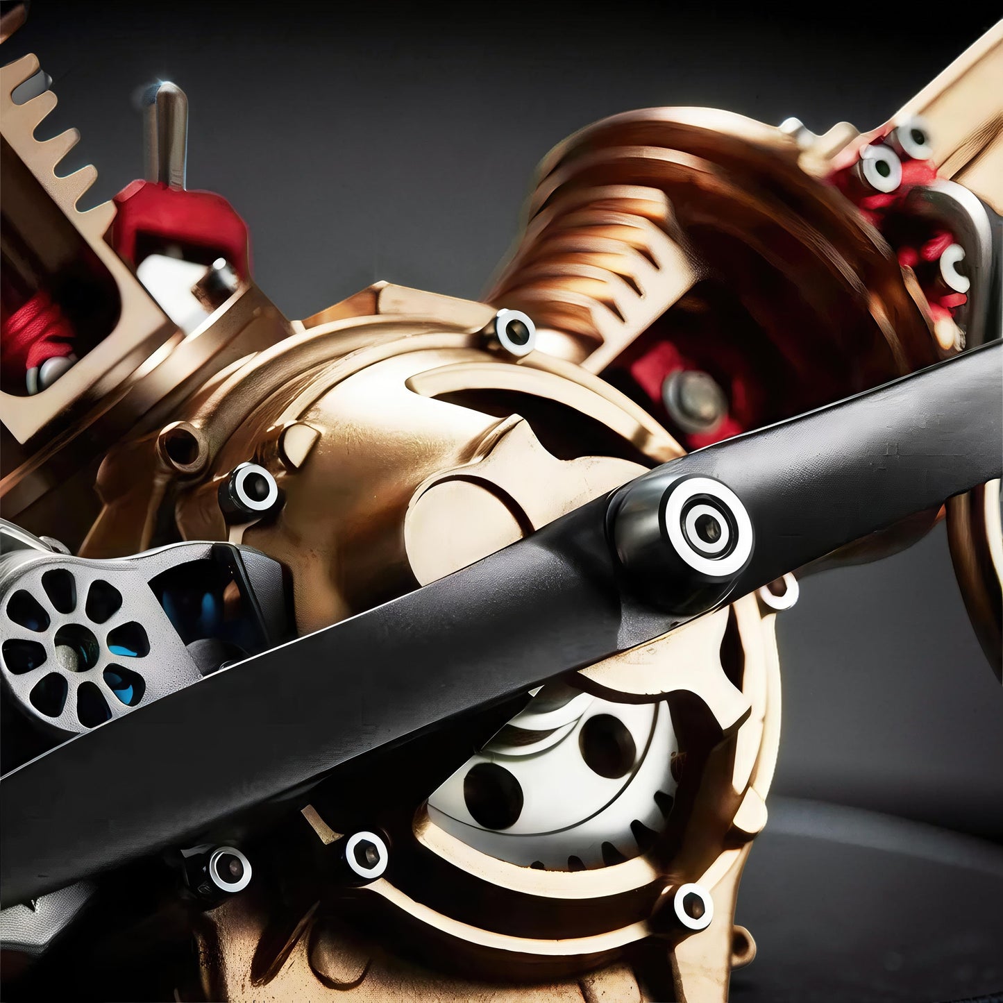 The Curious Mind Mini V2 Double-Cylinder Engine DIY Kit, a premium metal mechanical model with gold and red accents and a black propeller.