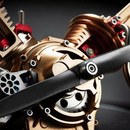 The Curious Mind Mini V2 Double-Cylinder Engine DIY Kit, a premium metal mechanical model with gold and red accents and a black propeller.